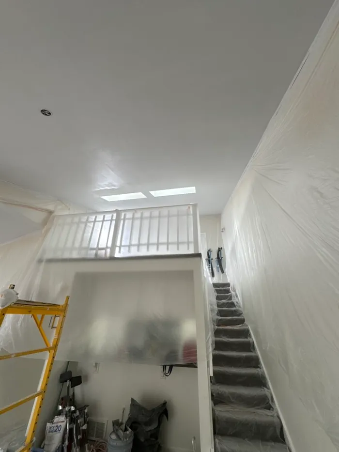 Same room with the popcorn removed, walls still protected in plastic