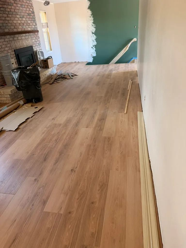 Vinyl plank flooring installed next to a brick fireplace