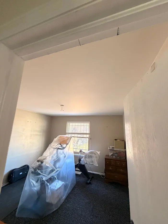 Same bedroom with a smooth finished ceiling