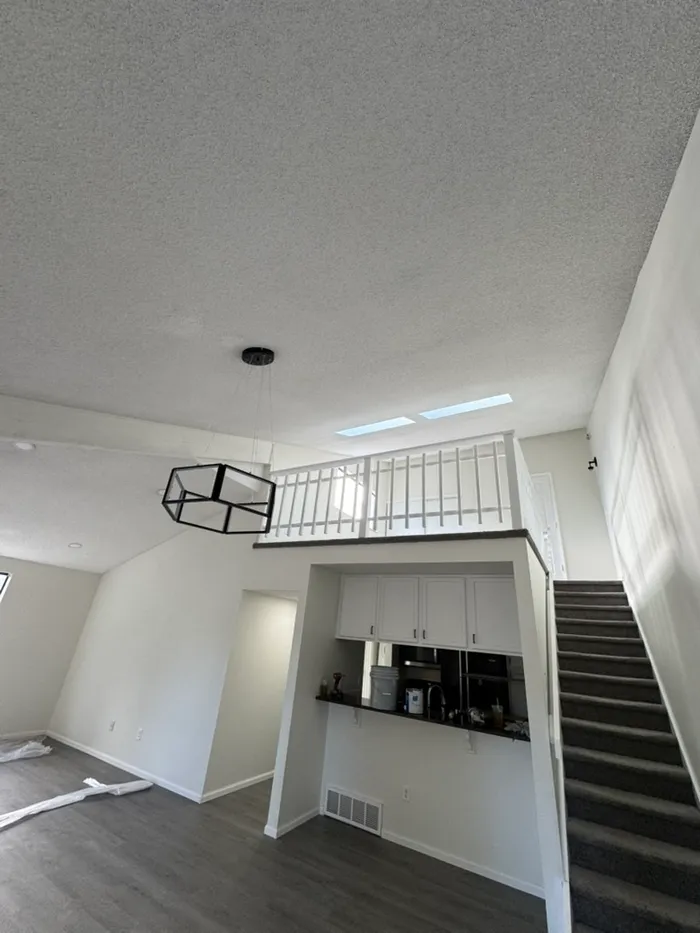 Vaulted living room and loft with popcorn ceiling