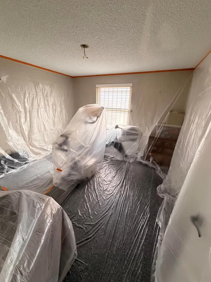 Bedroom sealed in plastic with popcorn ceiling